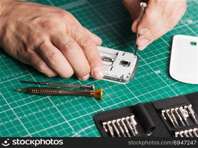 Man repairing broken smartphone, close up photo. Man repairing broken smartphone, close up photo.