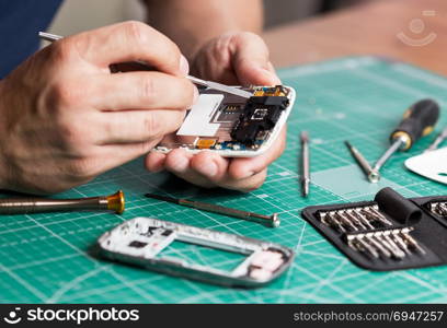 Man repairing broken smartphone, close up photo. Man repairing broken smartphone, close up photo.