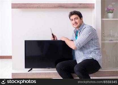 Man repairing broken tv at home