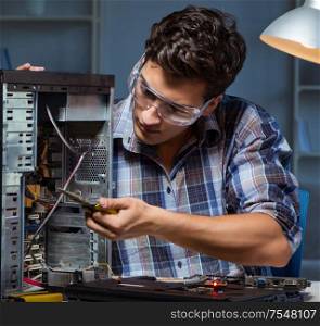 Man repairing computer desktop with pliers. The man repairing computer desktop with pliers