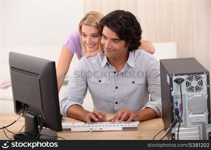 Man repairing computer for attractive blond