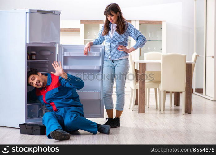 Man repairing fridge with customer