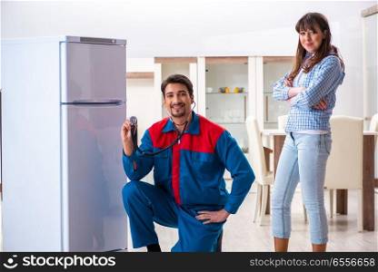 Man repairing fridge with customer