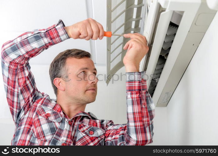 Man repairing his air conditioning system