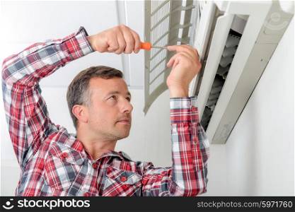 Man repairing his air conditioning system