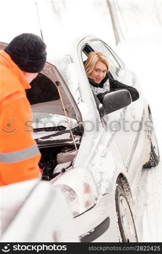 Man repairing woman&acute;s car snow assistance winter broken tools mechanic