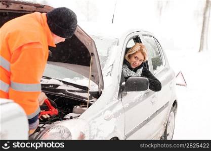 Man repairing woman&acute;s car snow assistance winter broken tools mechanic