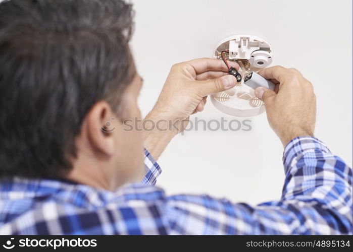 Man Replacing Battery In Home Smoke Alarm