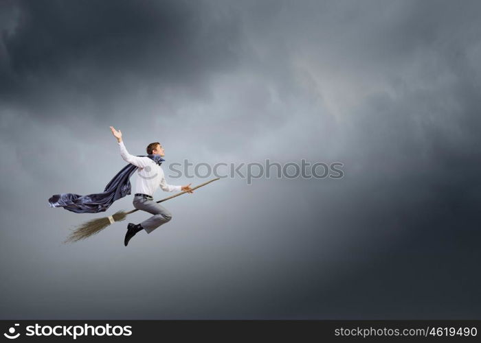 Man ride broom. Young businessman flying on broom high in sky