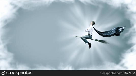 Man ride broom. Young businessman flying on broom high in sky