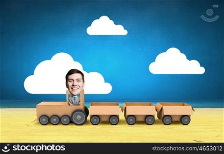 Man ride paper train . Funny cartoon image of businessman riding carton box