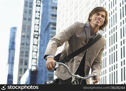 Man riding bicycle in downtown district, low angle view