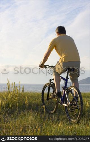 Man riding his bicycyle at the sea in the morning