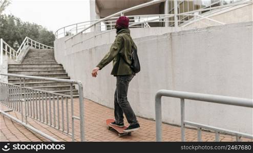 man riding his skateboard outside city