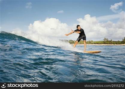 man riding his surfboard having good time long shot