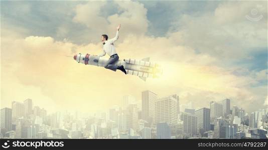 Man riding missile. Young businessman flying in sky on space rocket