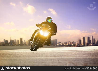 man riding sport motorcycle lean on curve road against urban skyline background