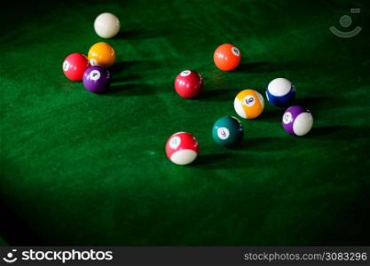 Man&rsquo;s hand and Cue arm playing snooker game or preparing aiming to shoot pool balls on a green billiard table. Colorful snooker balls on green frieze