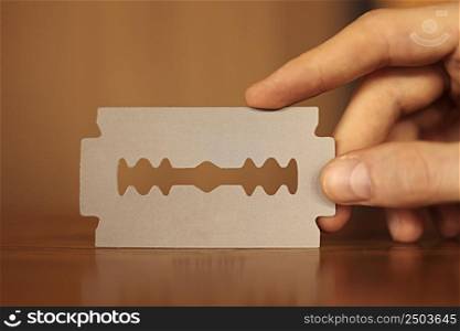 man&rsquo;s hand holding empty business card in the form of a blade for beauty salon, barbershop. stylish free blank copy space. . High quality photo.. man&rsquo;s hand holding empty business card in the form of a blade for beauty salon, barbershop. stylish free blank copy space. . High quality photo