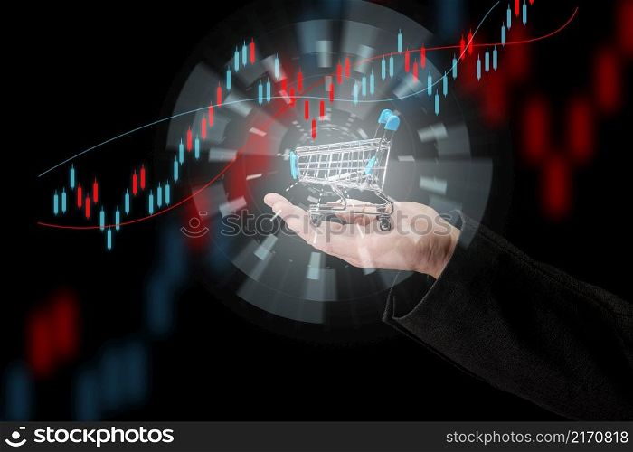 man&rsquo;s hand holds a miniature shopping cart on a dark blue background, the concept of the start of world sales, the growth of purchases. Online shopping