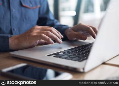 Man&rsquo;s hand is typing on the laptop keyboard.