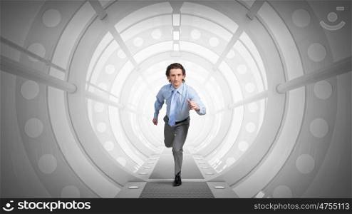 Man run in virtual room mixed media. Young businessman running in futuristic 3D tunnel