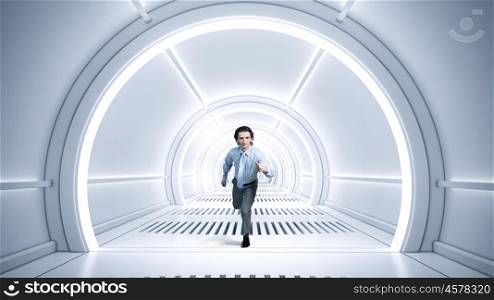 Man run in virtual room. Young businessman running in futuristically designed tunnel
