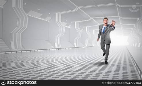 Man running and reaching hand. Young screaming businessman running in futuristic tunnel