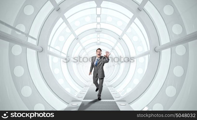 Man running and reaching hand. Young screaming businessman running in futuristic tunnel