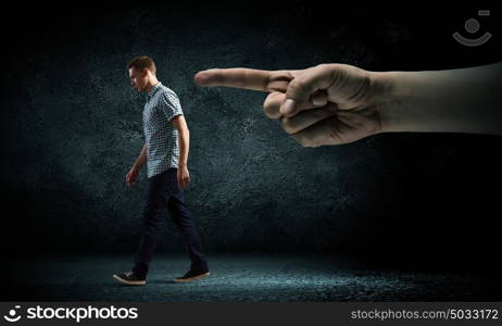 Man running away. Funny image of young man and huge hand