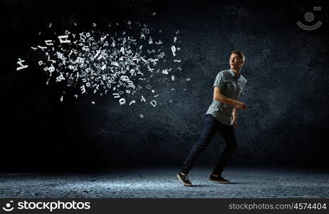 Man running away. Funny image of young man trying to escape from flying letters