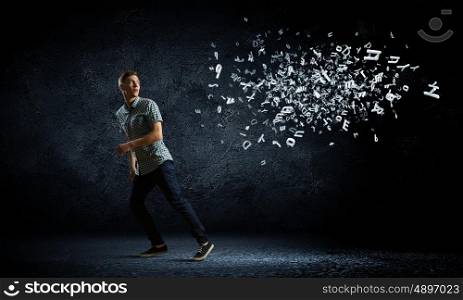 Man running away. Funny image of young man trying to escape from flying letters