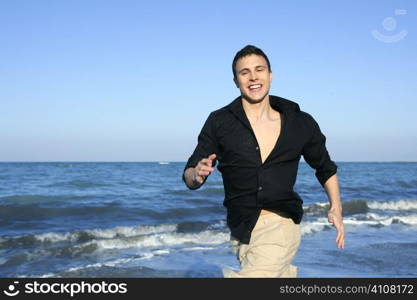 Man running happy on the blue summer beach, sunny summer