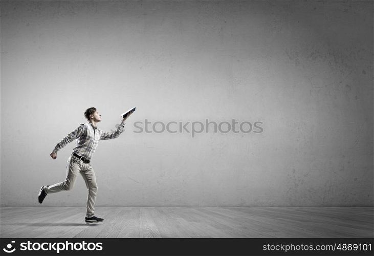 Man running with book. Funny student guy running with opened book in hand
