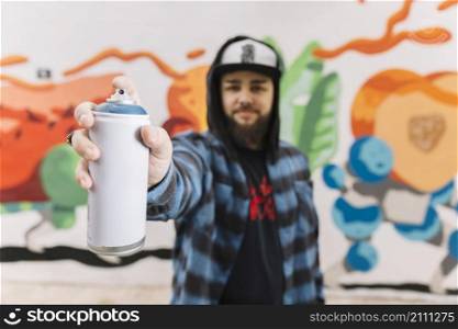 man s hand holding white aerosol can