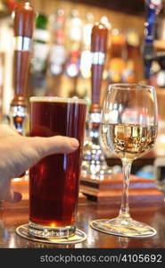 man s hand taking a pint of beer from bar