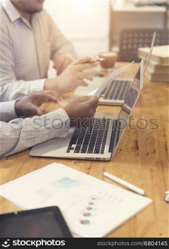 man's hand working with business document and laptop computer notebook for working concept, selective focus and vintage tone