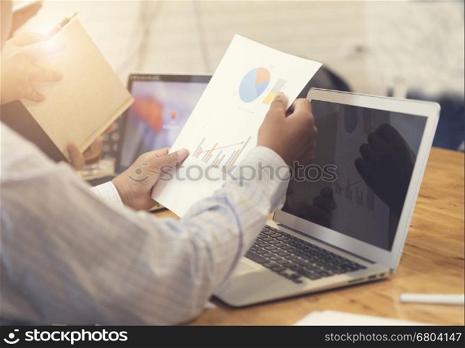 man's hand working with business document and laptop computer notebook for working concept, selective focus and vintage tone