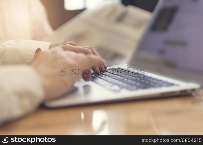 man's hand working with laptop computer notebook for working concept, selective focus and vintage tone