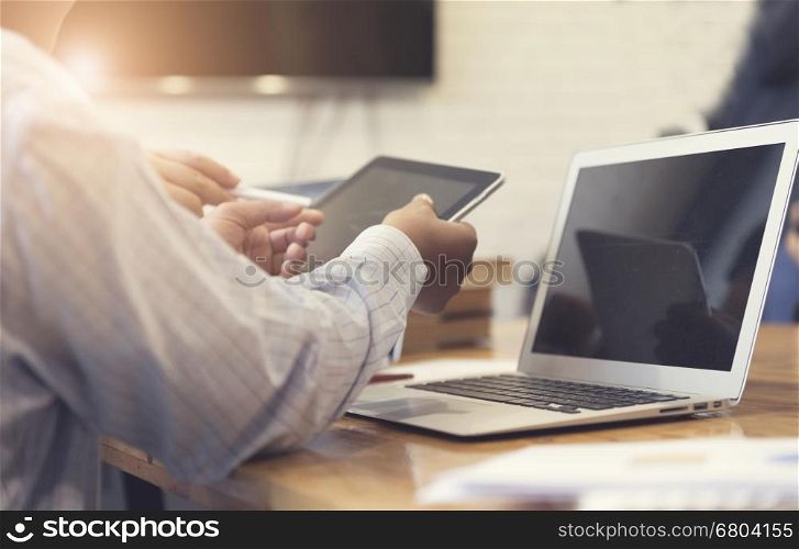 man's hand working with tablet, business document and laptop computer notebook for working concept, selective focus and vintage tone