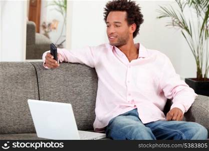 Man sat at home with laptop and mobile