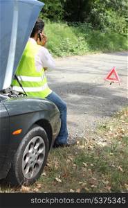 Man sat by car waiting for roadside assistance