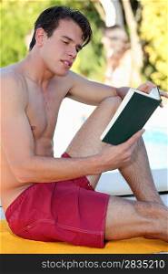 Man sat by pool reading book