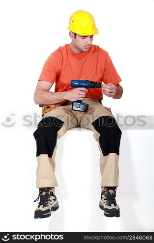 Man sat holding cordless drill