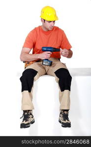 Man sat holding cordless drill