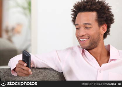 Man sat on sofa sending text message