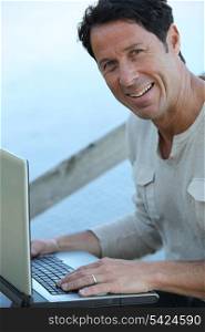 Man sat outdoors with laptop