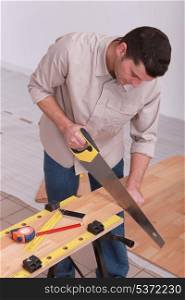 Man sawing laminate flooring