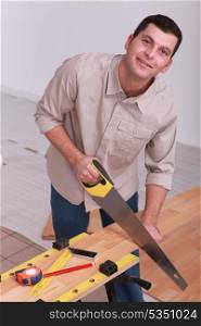 Man sawing wooden floorboards