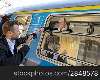 Man saying goodbye to woman on train smiling window commuter